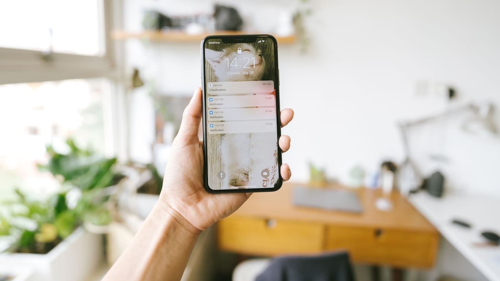 Tangan memegang ponsel yang menampilkan percakapan chat